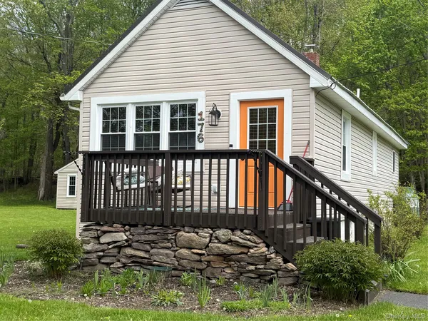 a view of a house with backyard and sitting area
