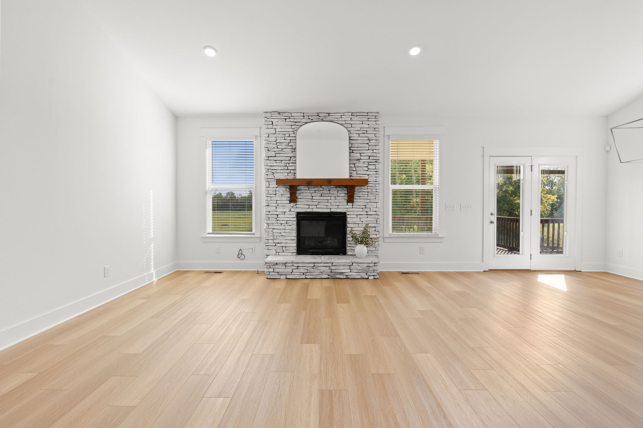 1257 Cotillion Drive Murfreesboro, TN 37128 - Photo 5 of 34 an empty room with wooden floor fireplace and windows
