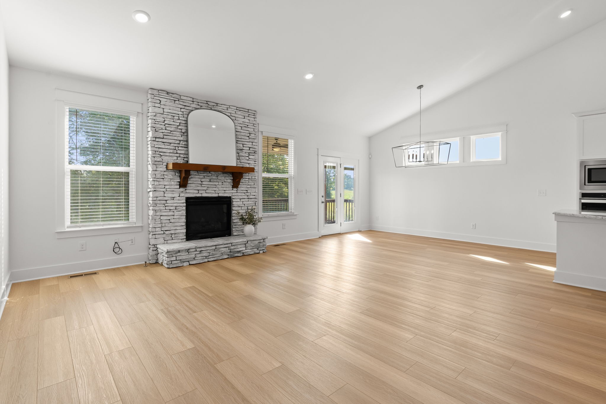 1257 Cotillion Drive Murfreesboro, TN 37128 - Photo 6 of 34 an empty room with wooden floor fireplace and windows