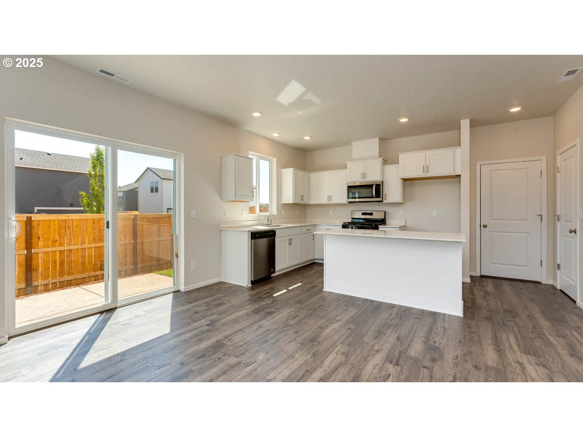 2960 U Street Springfield, OR 97477 - Photo 5 of 24 a open kitchen with white cabinets and stainless steel appliances