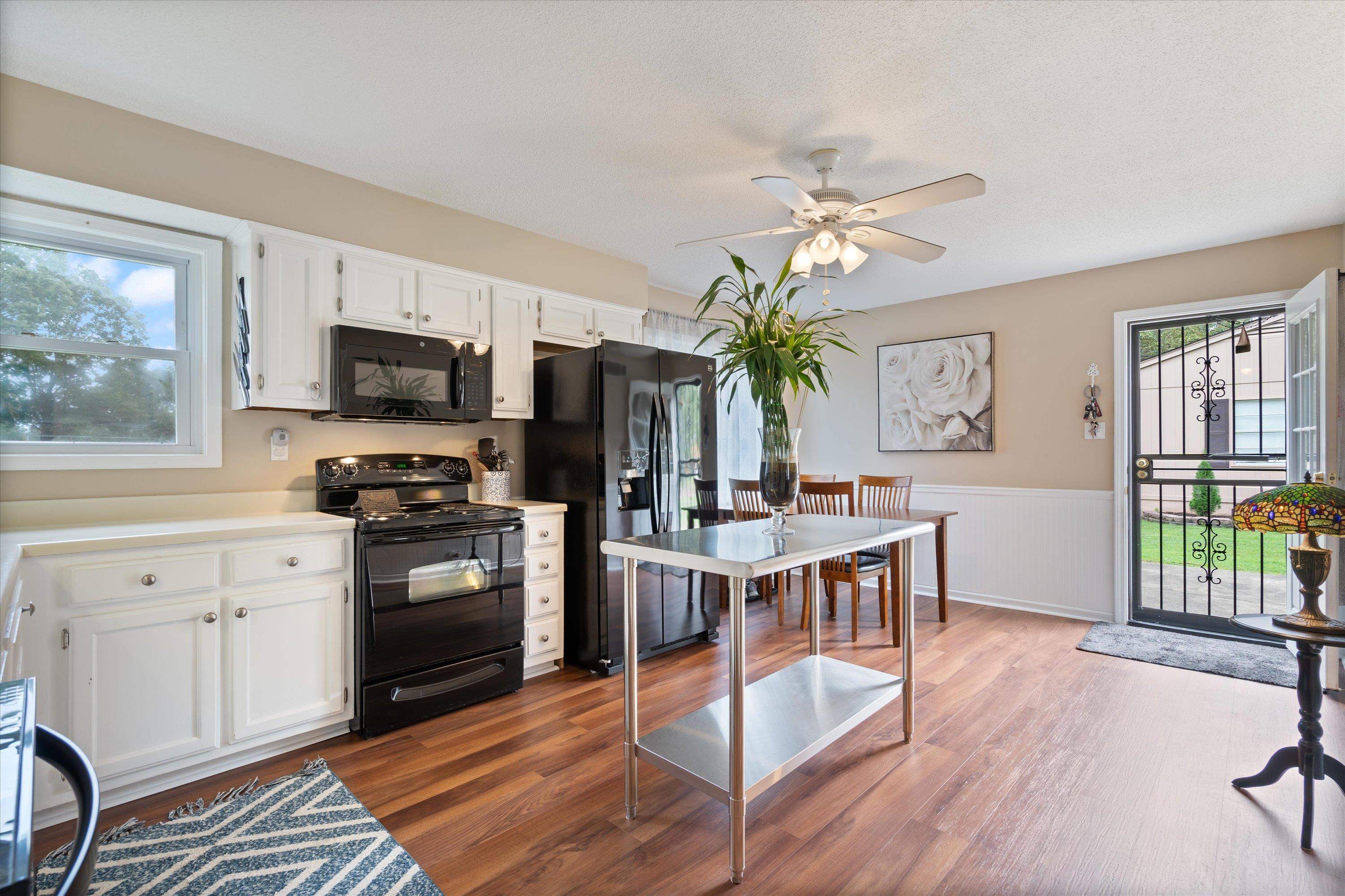 970 Poplar Leaf Road Collierville, TN 38017 - Photo 7 of 20 a kitchen with kitchen island a large counter top space appliances and a ceiling fan