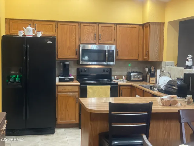 a kitchen with a refrigerator and a stove top oven