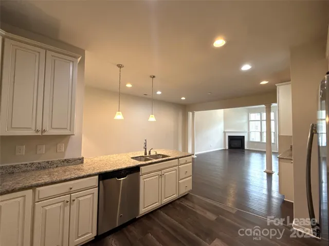 a large kitchen with stainless steel appliances granite countertop a sink a stove and a wooden floors