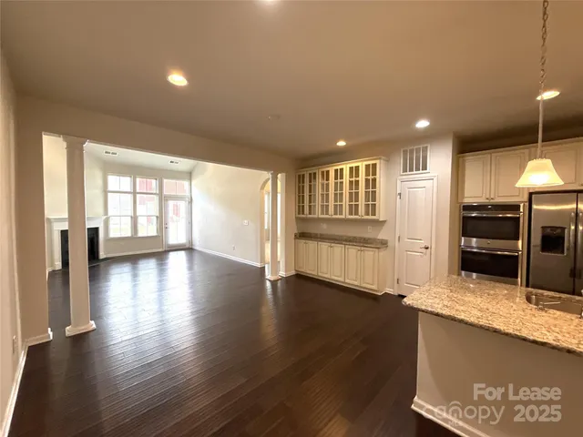 a view of a kitchen with a sink and dishwasher a oven with wooden floor