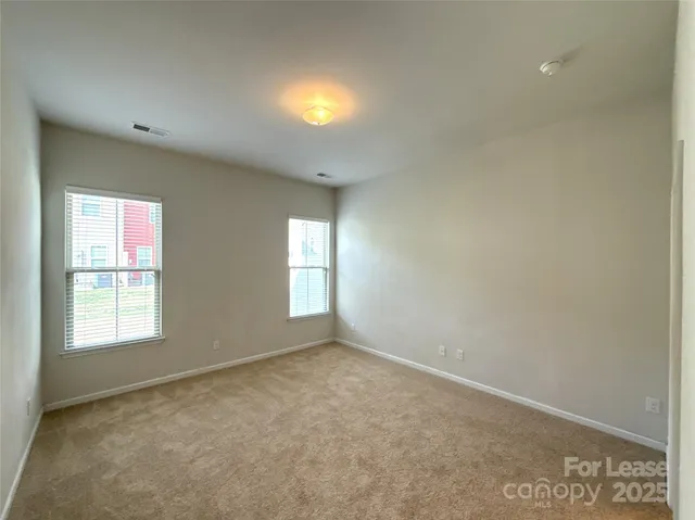 a spacious bathroom with a granite countertop double vanity sink a mirror and a toilet