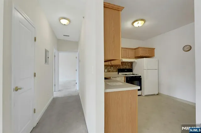 a kitchen with stainless steel appliances granite countertop a sink a stove a refrigerator with white cabinets