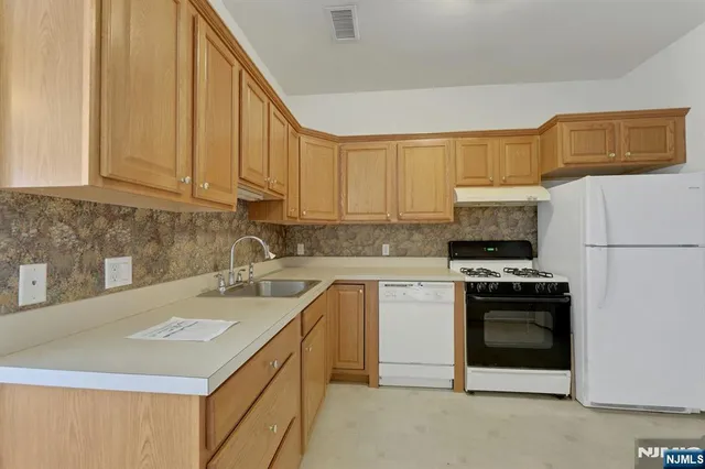 a kitchen with cabinets appliances and a sink