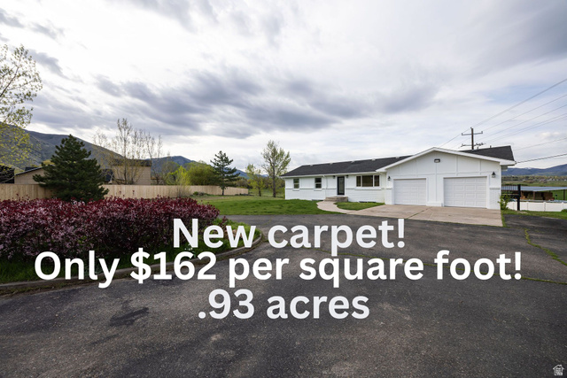 4155 Johnson Road Nibley, UT 84321 - Photo 1 of 71 Single-story residence featuring a two-car garage with white paneled doors and a paved driveway