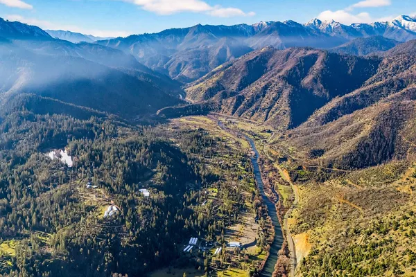 a view of a house with a mountain and trees
