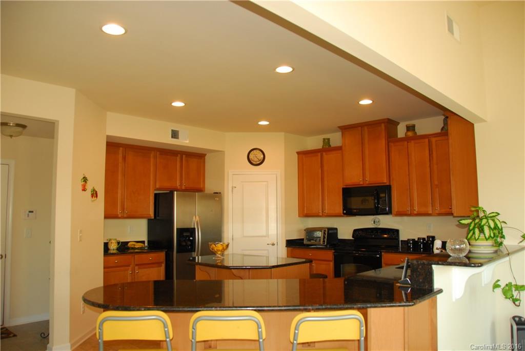 2181 Galloway Lane Southwest Concord, NC 28025 - Photo 6 of 11 a kitchen with stainless steel appliances kitchen island granite countertop a refrigerator a stove top oven and a sink with granite countertops