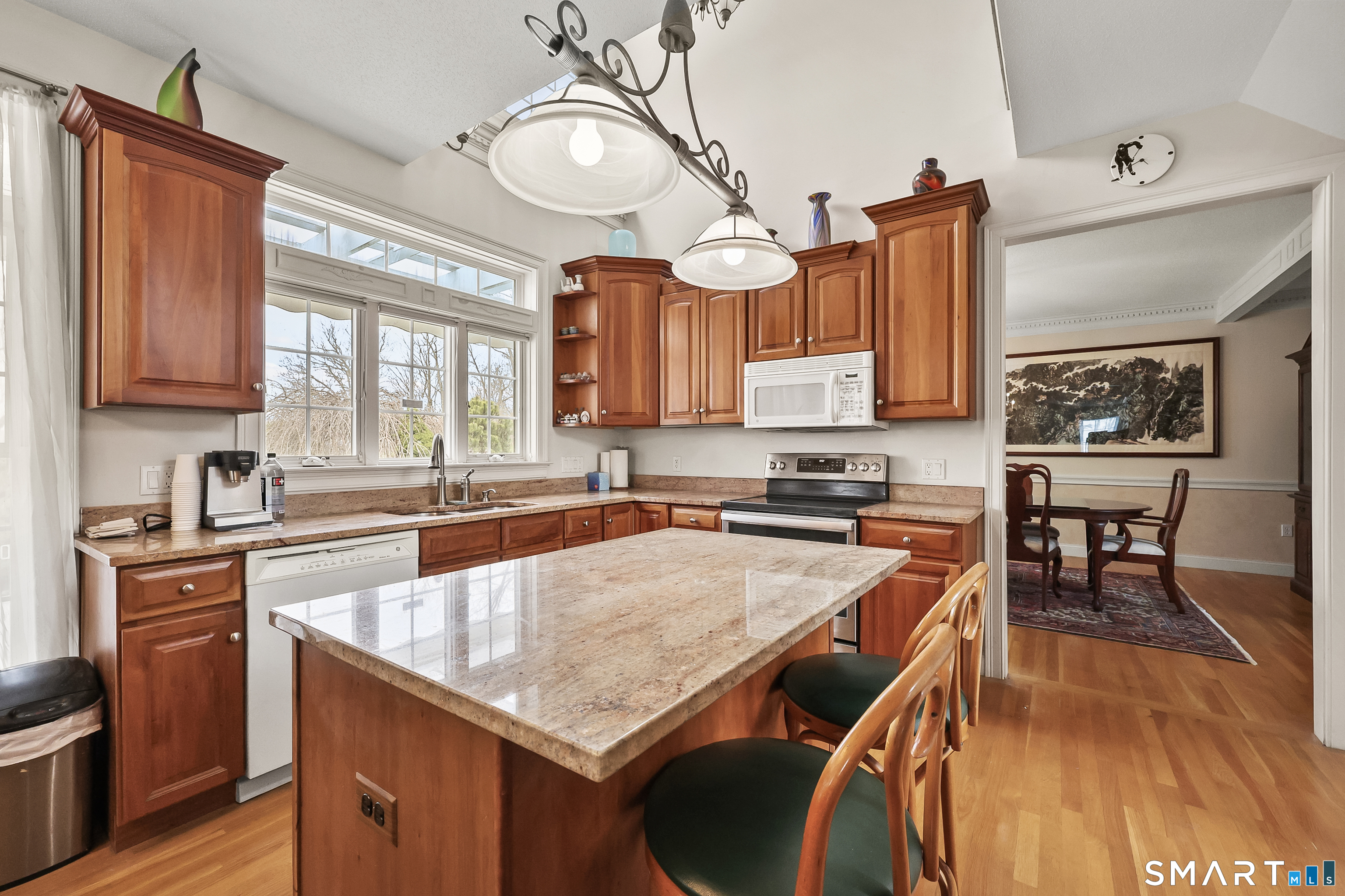 87 Wanda Lane Middletown, CT 06457 - Photo 13 of 39 a kitchen with granite countertop a stove a sink and dishwasher wooden cabinets with wooden floor