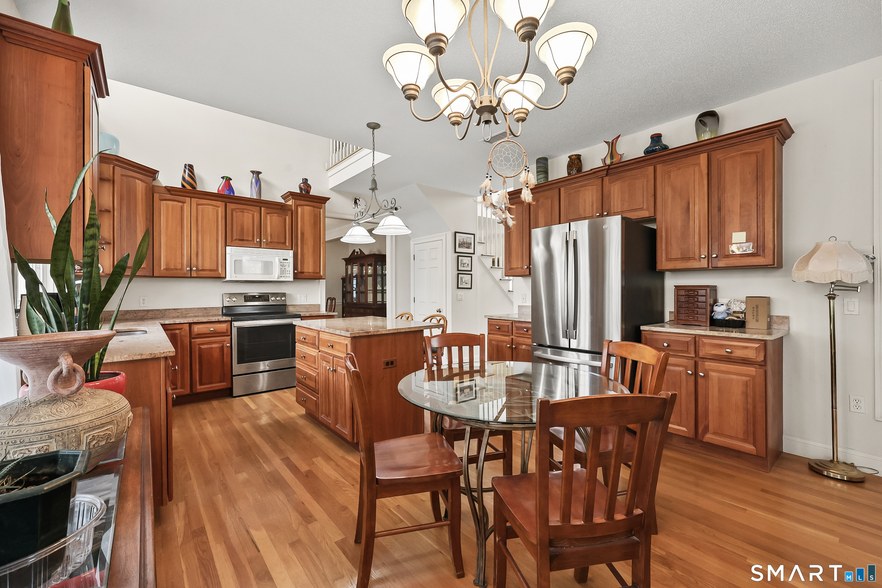 87 Wanda Lane Middletown, CT 06457 - Photo 14 of 39 a dining room with stainless steel appliances granite countertop a dining table a stove top oven a chimney and a kitchen island