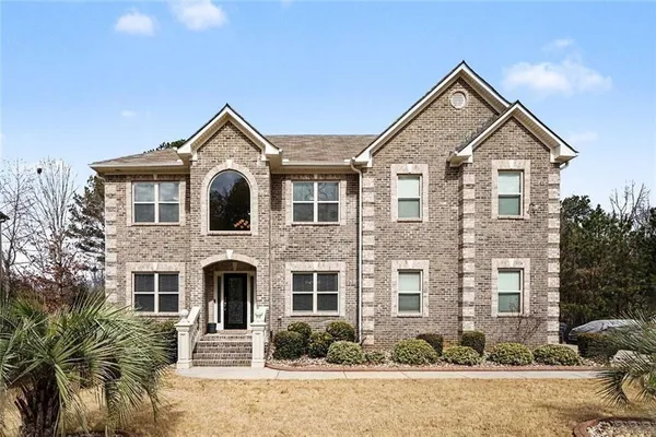 a front view of a house with a garden