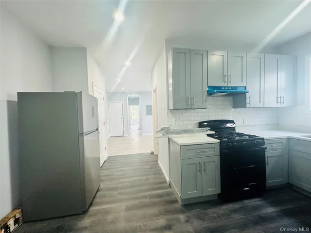 a kitchen with a refrigerator and a stove top oven