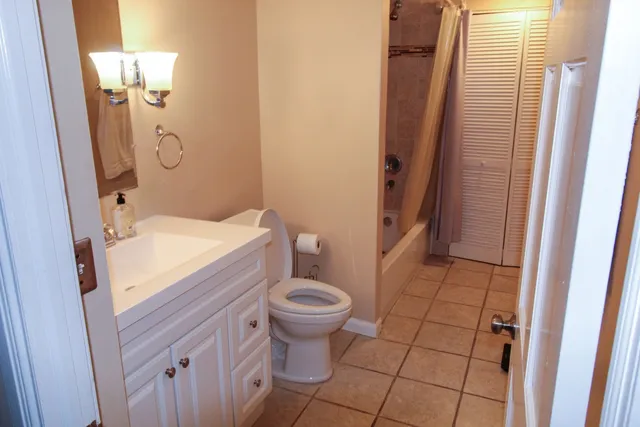 a bathroom with a sink a toilet a mirror and shower