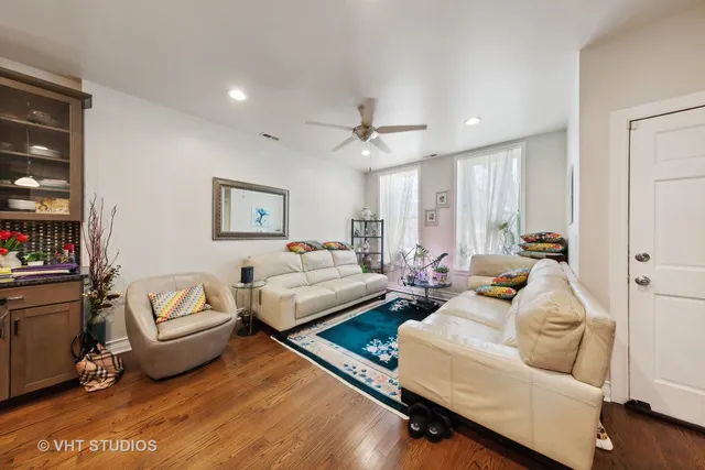 a living room with furniture rug and a ceiling fan
