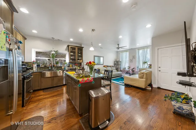 a living room with furniture kitchen view and a wooden floor