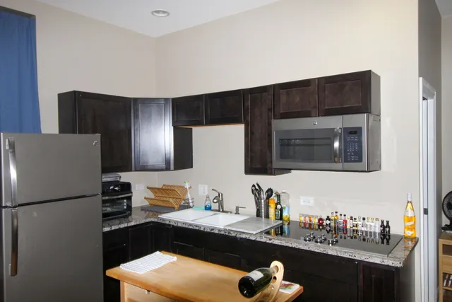 a kitchen with stainless steel appliances granite countertop a refrigerator and a stove top oven