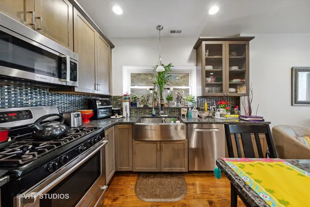 a kitchen with stainless steel appliances granite countertop a stove and a sink