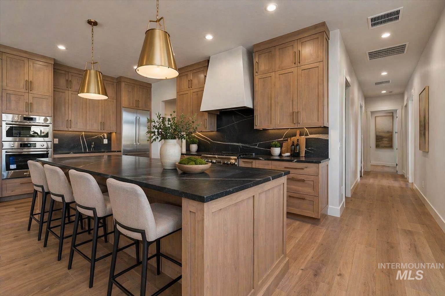 539 Century Avenue Middleton, ID 83644 - Photo 16 of 50 Kitchen with decorative backsplash, stainless steel appliances, light wood-style floors, a kitchen bar, and pendant lighting