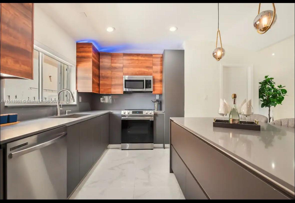14236 Southwest 164th Terrace Miami, FL 33177 - Photo 17 of 29 a kitchen with stainless steel appliances granite countertop a sink a stove and a wooden cabinets