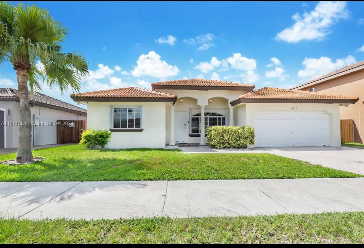 14236 Southwest 164th Terrace Miami, FL 33177 - Photo 29 of 29 a white house with a yard and a large parking space
