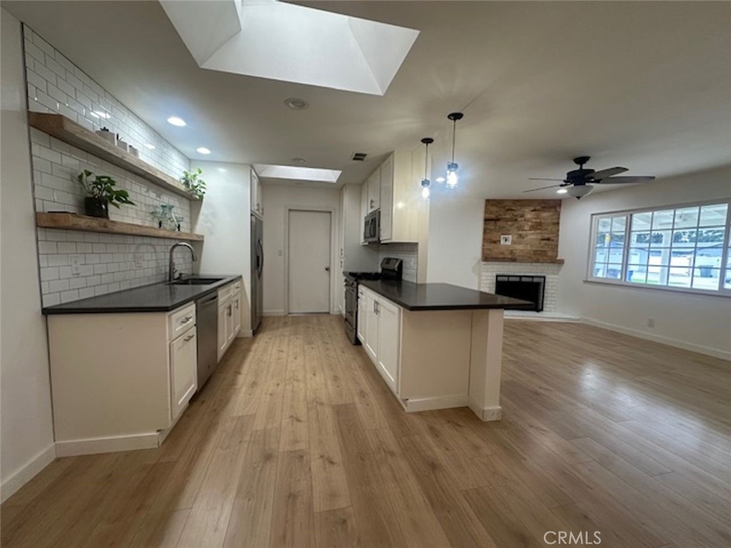 8772 Sumner Place Cypress, CA 90630 - Photo 2 of 8 a view of a kitchen with kitchen island a sink wooden floor and a large window