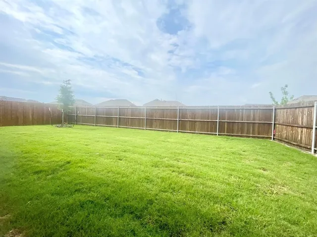 a view of a yard with a wooden fence