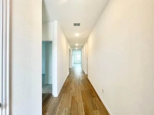 a view of a hallway with wooden floor