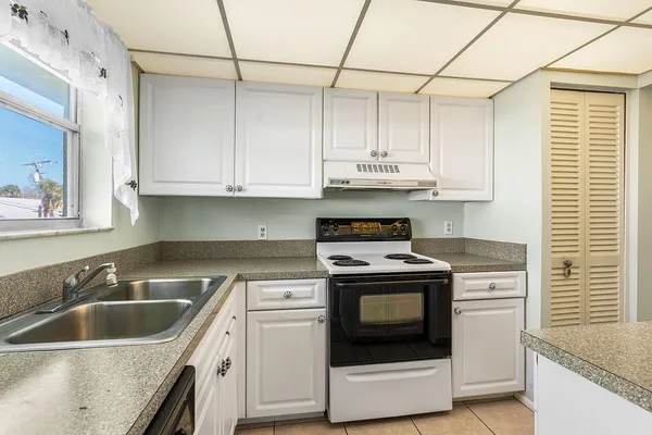 a kitchen with stainless steel appliances granite countertop a sink stove and cabinets
