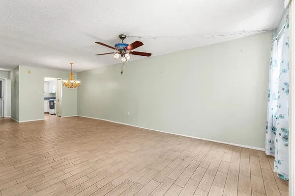 a view of a room with a wooden floor and a ceiling fan