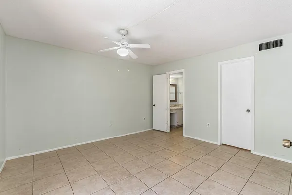 an empty room with closet and fan
