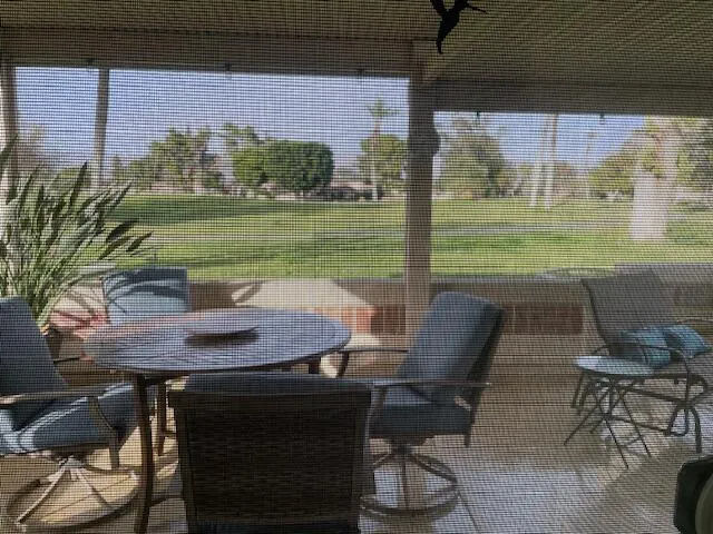 a view of a chairs and table in patio with a yard