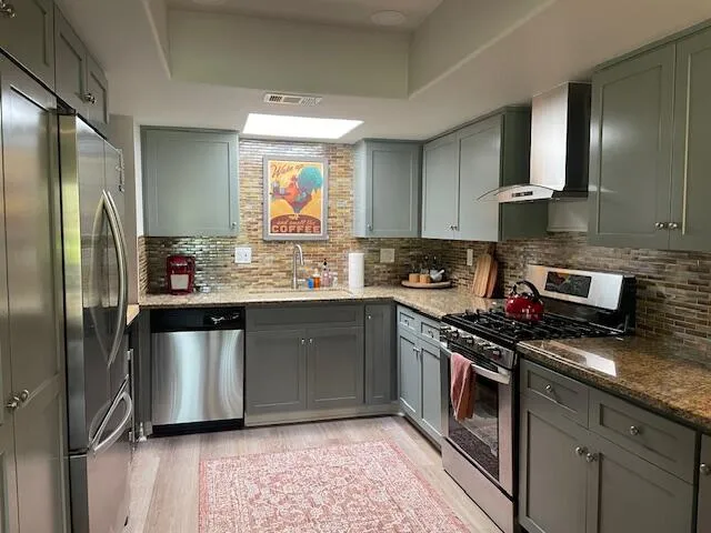 a kitchen with stainless steel appliances granite countertop a sink stove and refrigerator