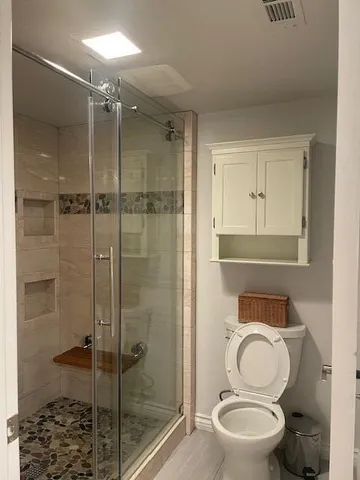 a bathroom with a toilet a sink and shower