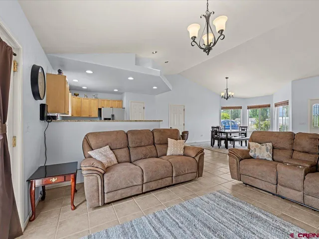 a living room with furniture a couch and kitchen view