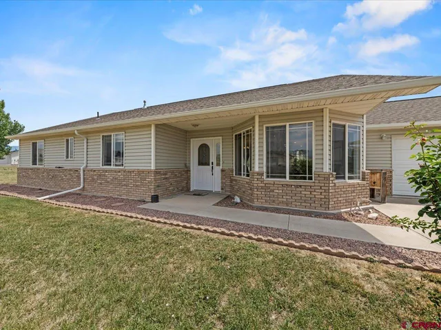 a view of a house with backyard and sitting area