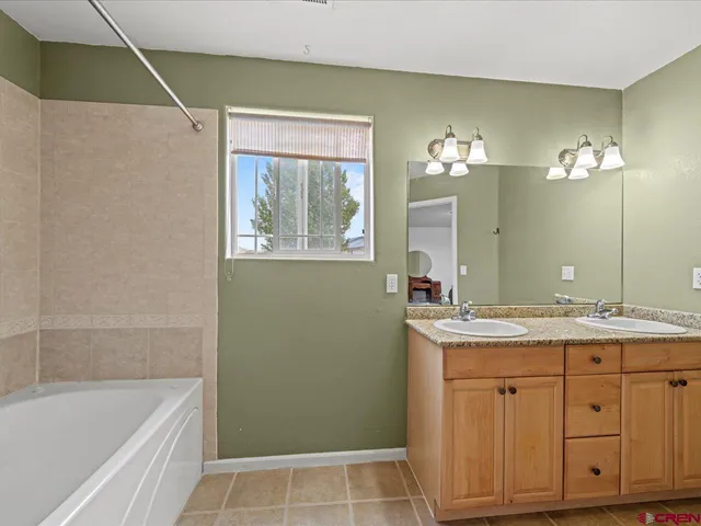 a bathroom with a granite countertop sink a toilet and bathtub