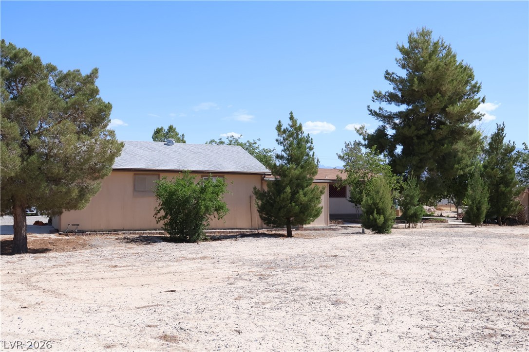 4501 East Kellogg Road Pahrump, NV 89061 - Photo 44 of 52 A spacious lot with established trees and a residence, offering ample outdoor potential.