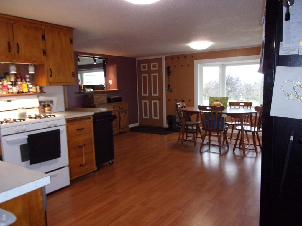 145 Main Road Westhampton, MA 01027 - Photo 9 of 30 a open kitchen with stainless steel appliances granite countertop a stove top oven a dining table and chairs with wooden floor