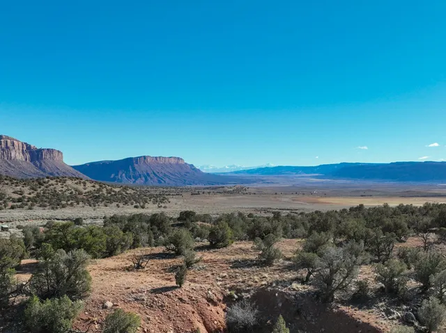 a view of a mountain with sunset in background