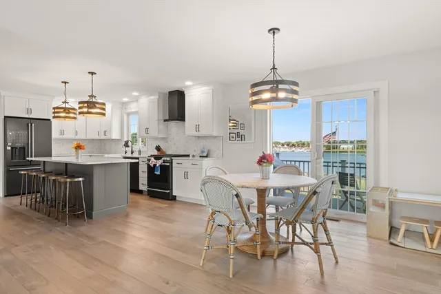 a view of a dining room and livingroom with furniture wooden floor a chandelier