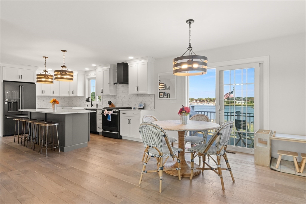 a view of a dining room and livingroom with furniture wooden floor a chandelier