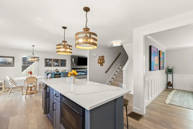 a kitchen with stainless steel appliances kitchen island granite countertop a stove and a wooden floor