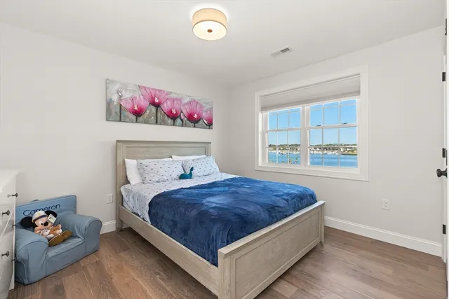 a bedroom with a bed and a painting on the wall