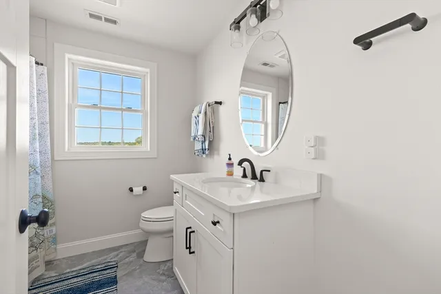 a bathroom with a toilet sink and mirror