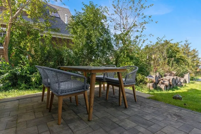 a patio with table and chairs and potted plants