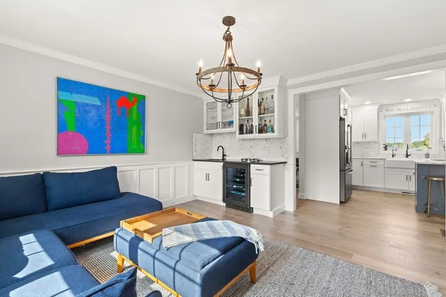 a living room with stainless steel appliances furniture and a kitchen view