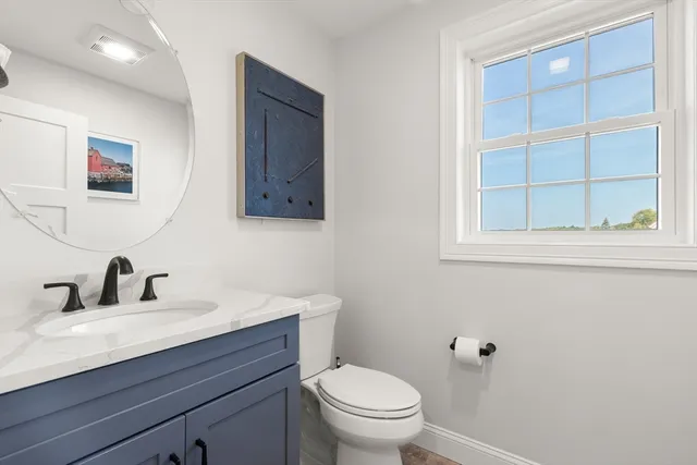 a bathroom with a toilet a sink and mirror