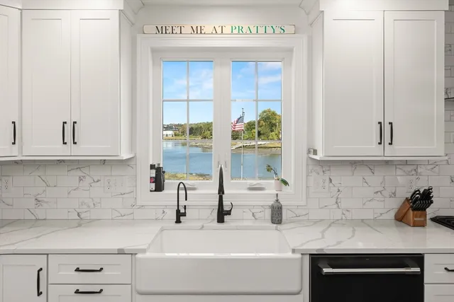 a kitchen with stainless steel appliances granite countertop a sink and a white cabinets